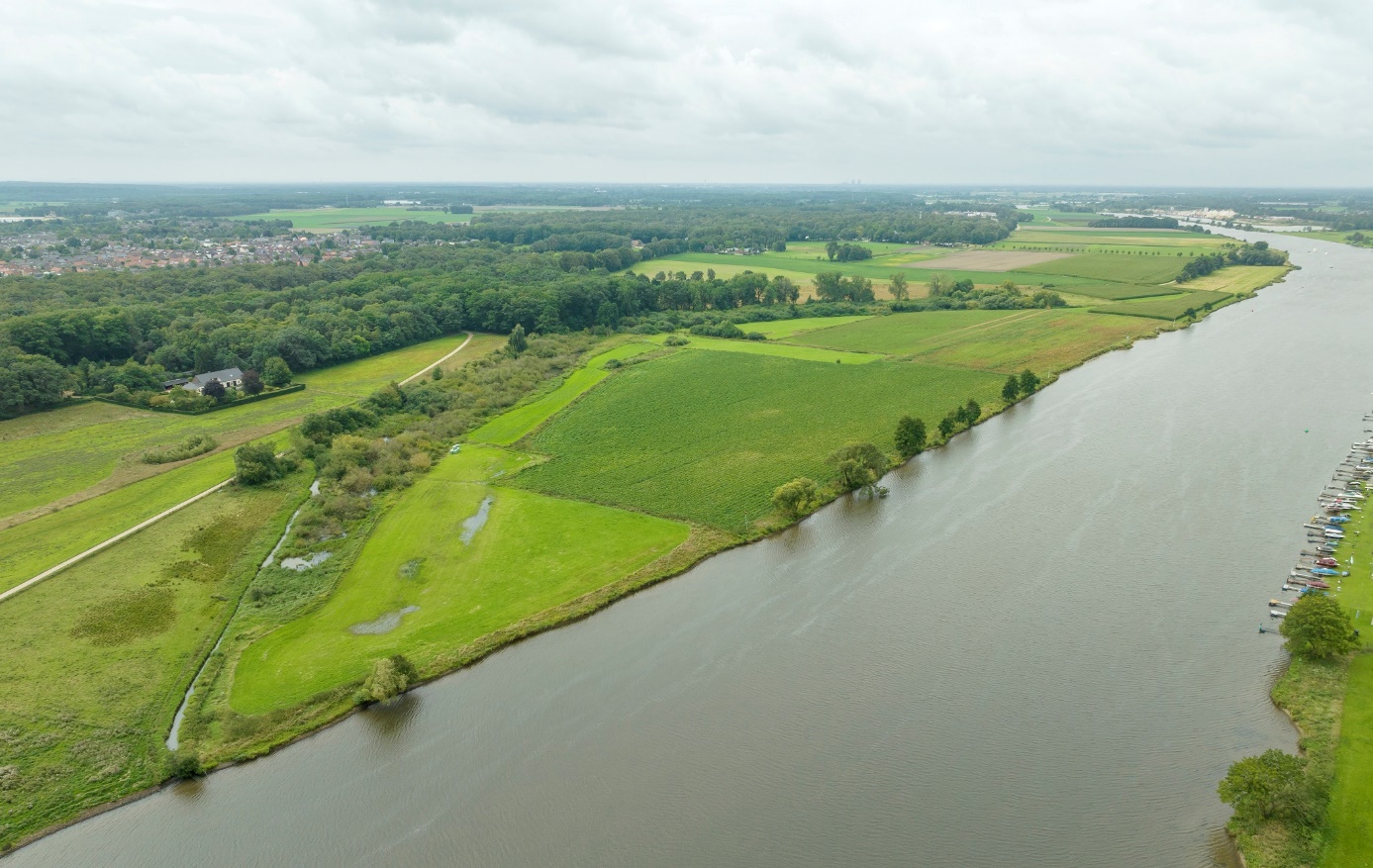 Foto van Geul De Weerd-Reuver met links het groene Reuver grenzend rechts aan de Maas.